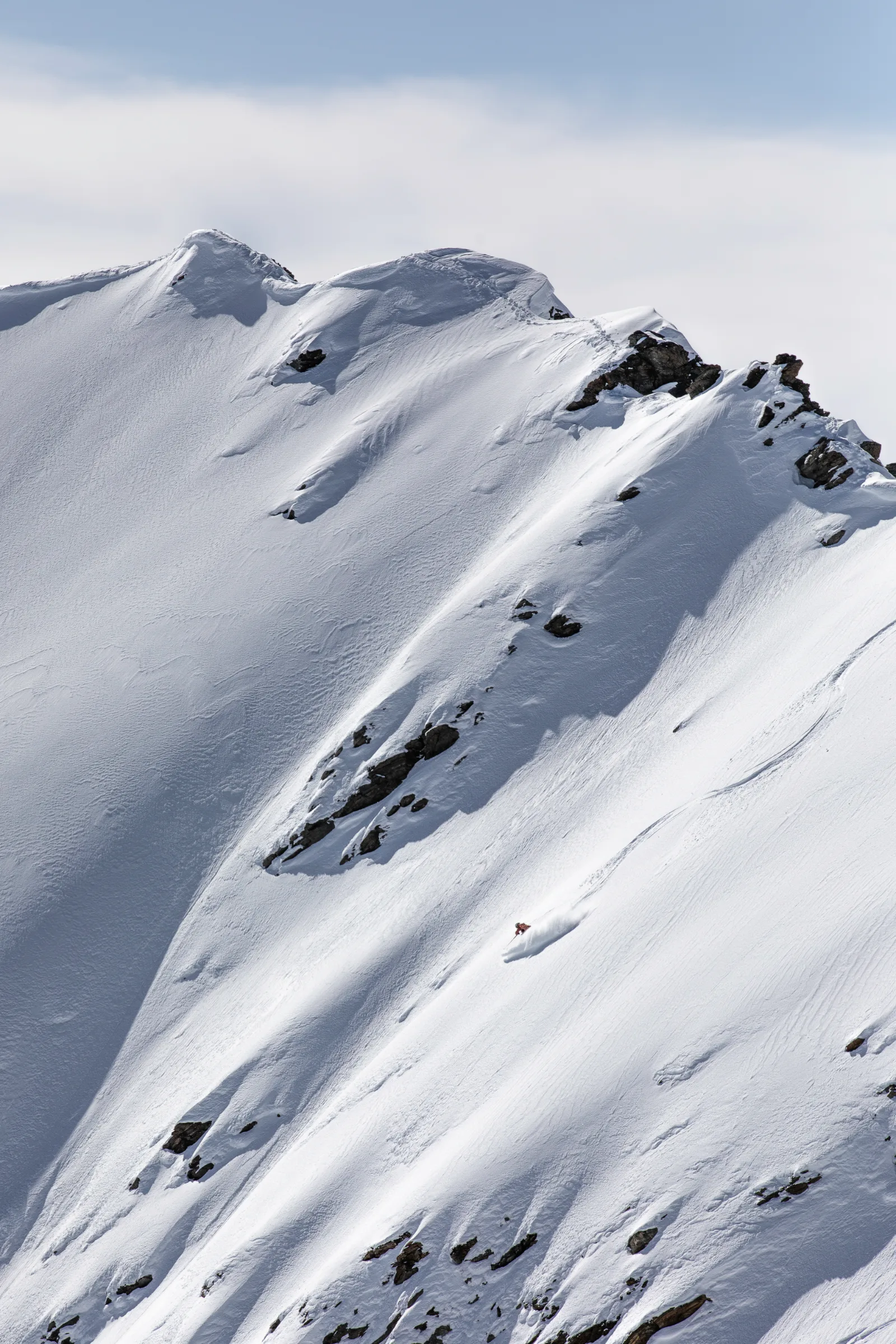 Schneebedeckte Berggrate mit felsigen Flanken und Skispuren in Lenzerheide, aufgenommen für Andrea Limbachers Galerie 2025.