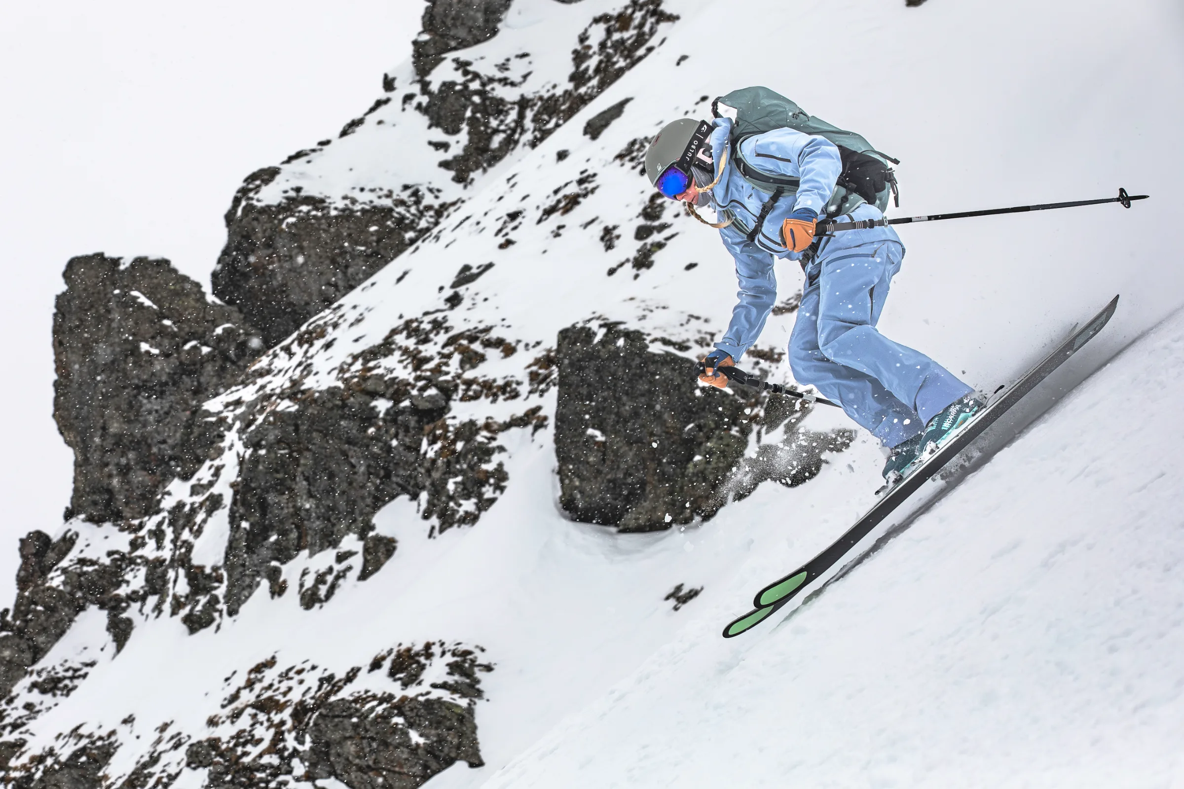 Michaela Casotti fährt in vorgebeugter Haltung einen steilen Schneehang vor dunklen, schneebedeckten Felswänden hinab.