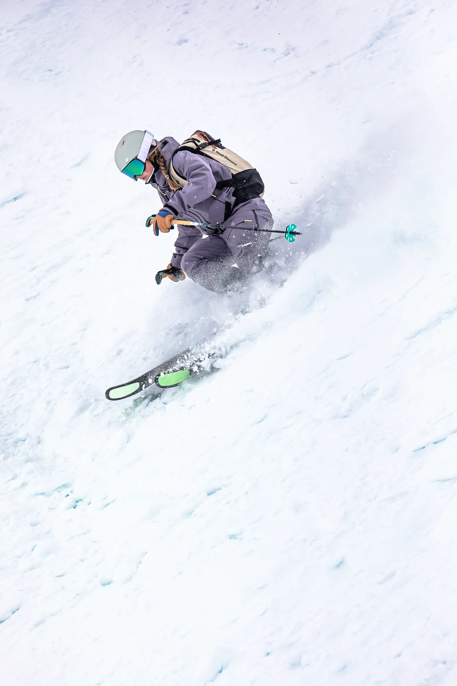 Ramona Arendt fährt in violetter Skikleidung tief gebeugt durch den Schnee, während neben ihren Ski Schnee aufwirbelt.
