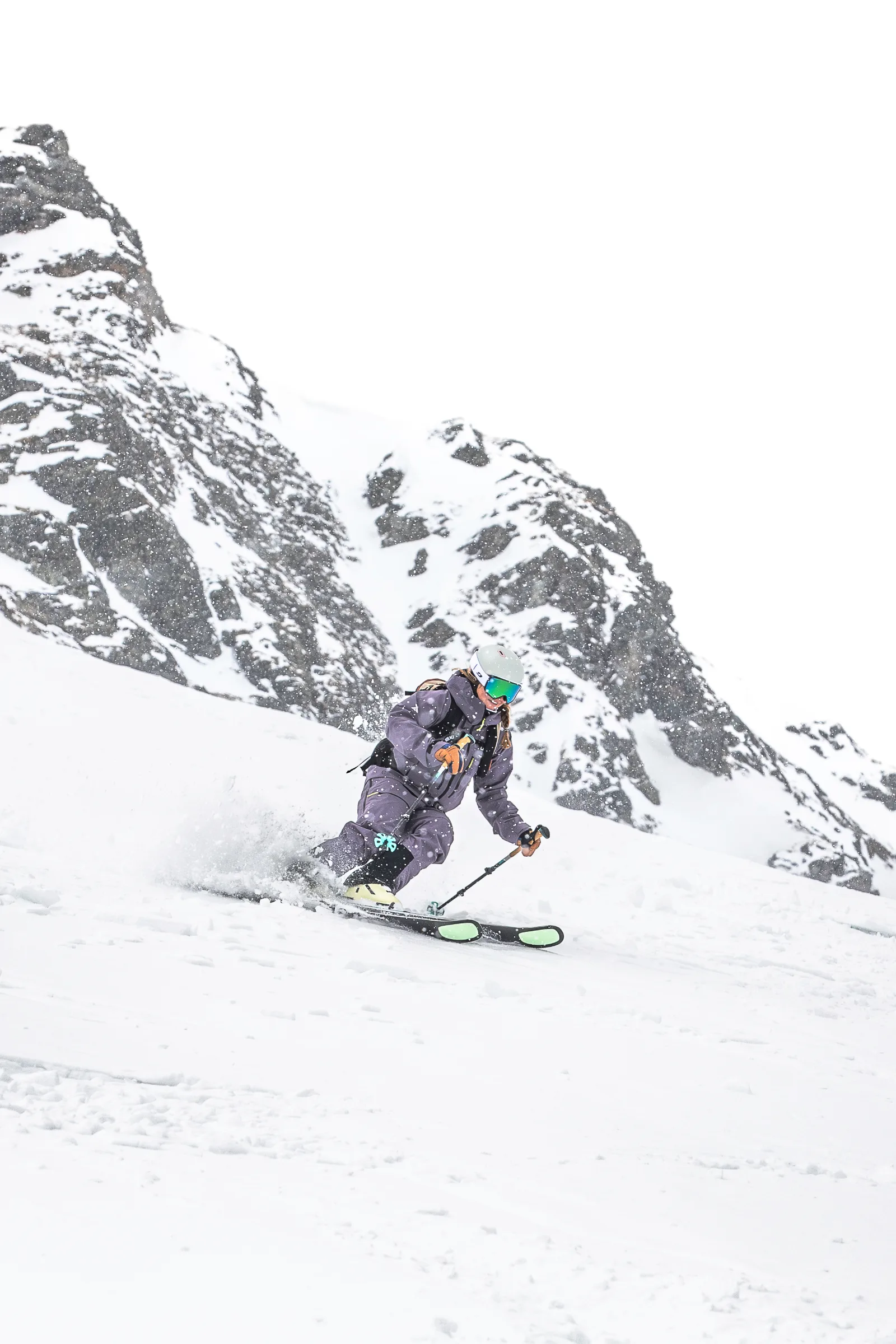 Ramona Arendt fährt einen Schwung auf einem offenen Schneehang in Lenzerheide, vor steilen, schneebedeckten Felswänden.